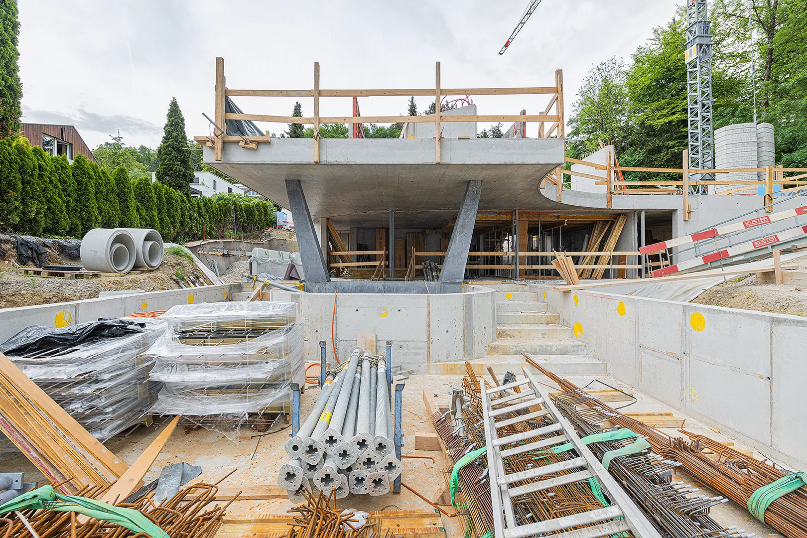 Architecture Photography of an exterior of the construction-site at Winkelhaus by architects Estudio KMMK, construction by atelier rosinus, structure by schnetzer puskas. Pool side with impressive concrete structure.