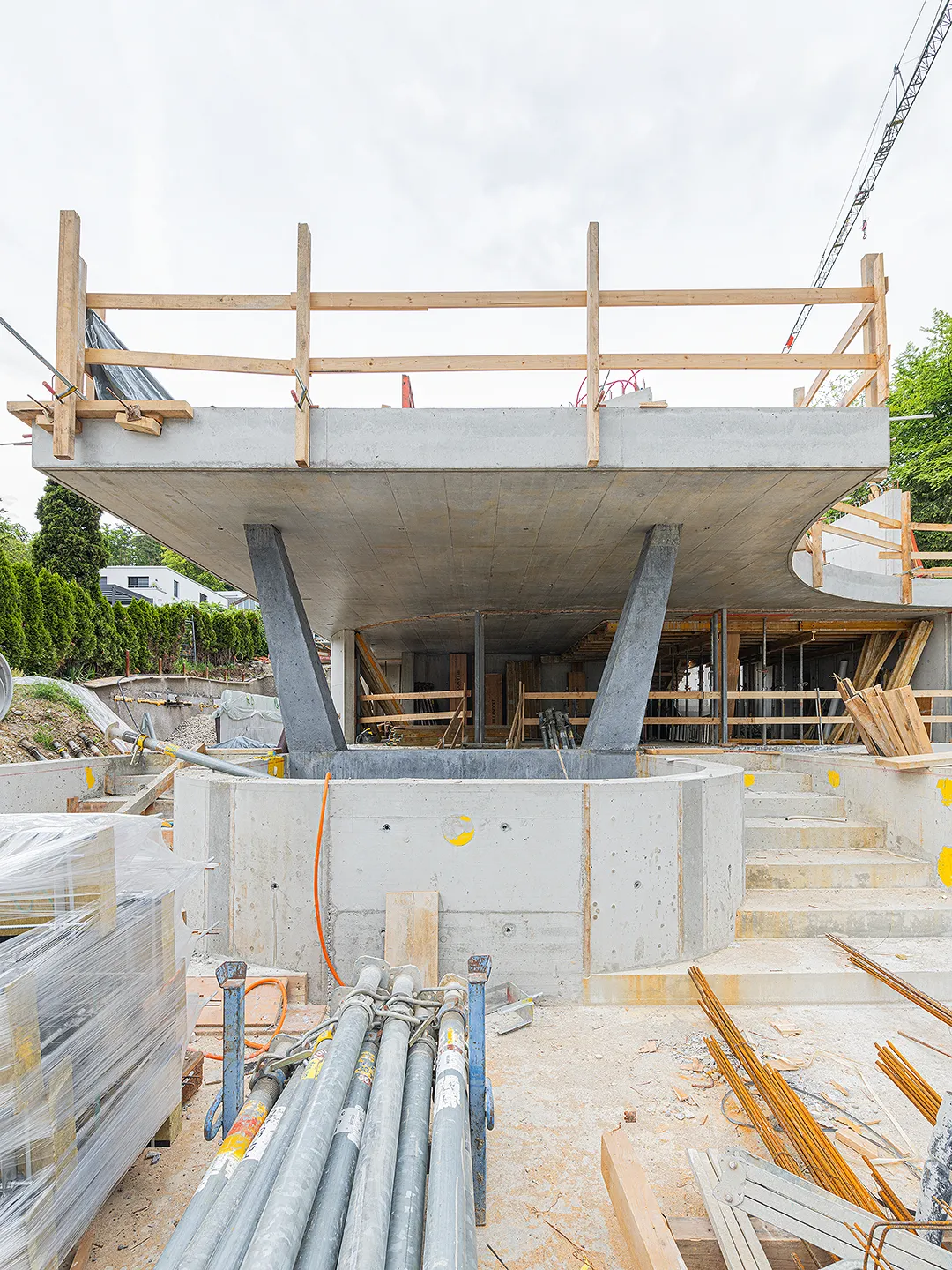 Architecture Photography of an exterior of the construction-site at Winkelhaus by architects Estudio KMMK, construction by atelier rosinus, structure by schnetzer puskas. Pool side with impressive concrete structure.