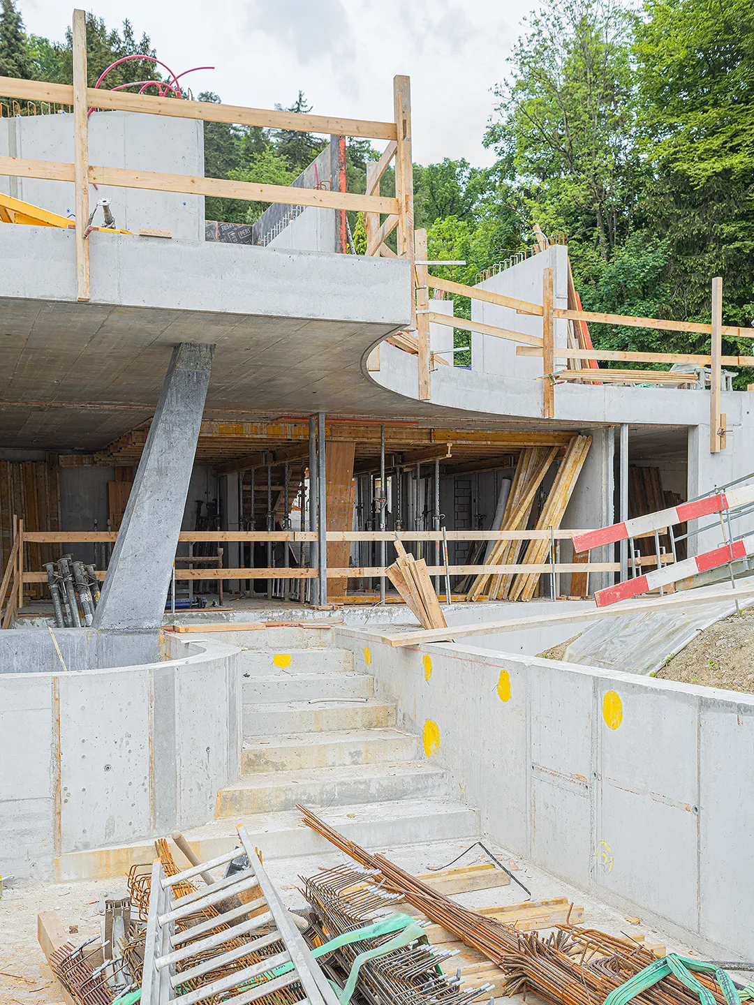 Architecture Photography of an exterior of the construction-site at Winkelhaus by architects Estudio KMMK, construction by atelier rosinus, structure by schnetzer puskas. Pool side with impressive concrete structure.