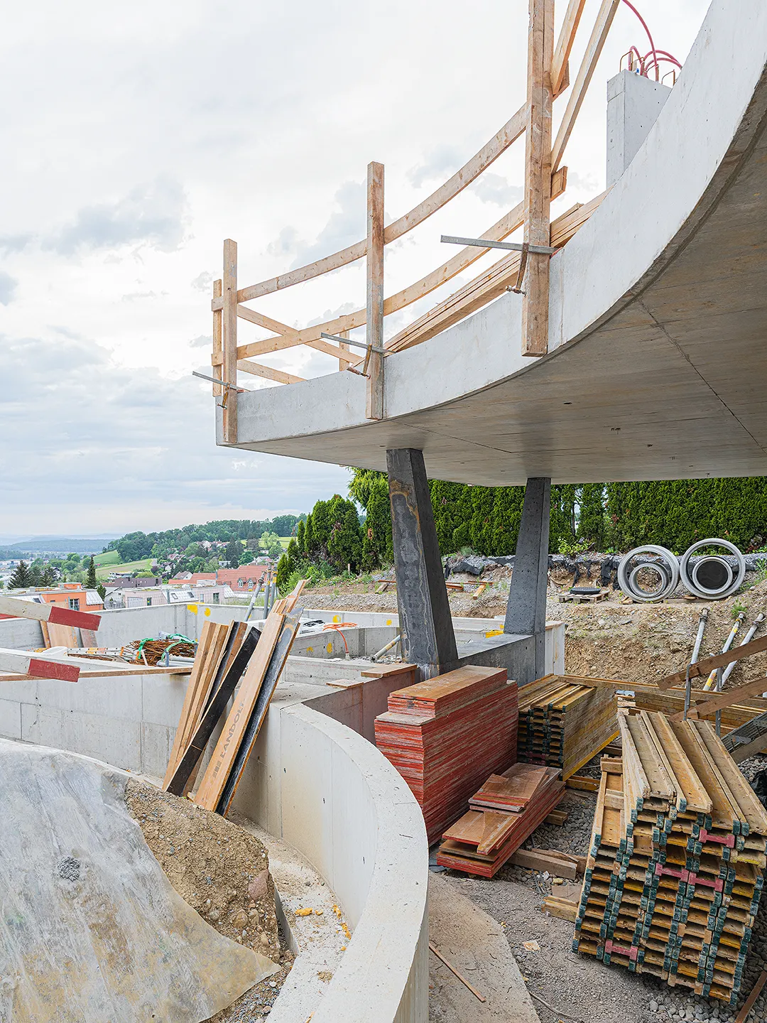 Architecture Photography of an exterior of the construction-site at Winkelhaus by architects Estudio KMMK, construction by atelier rosinus, structure by schnetzer puskas. Pool side with impressive concrete structure.