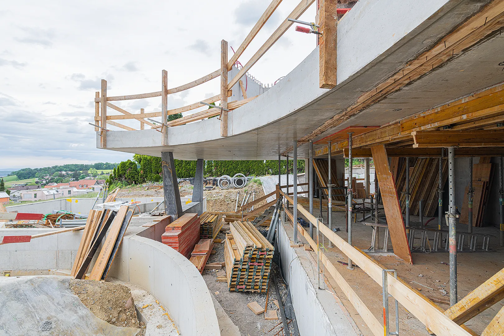 Architecture Photography of an exterior of the construction-site at Winkelhaus by architects Estudio KMMK, construction by atelier rosinus, structure by schnetzer puskas. Pool side with impressive concrete structure.