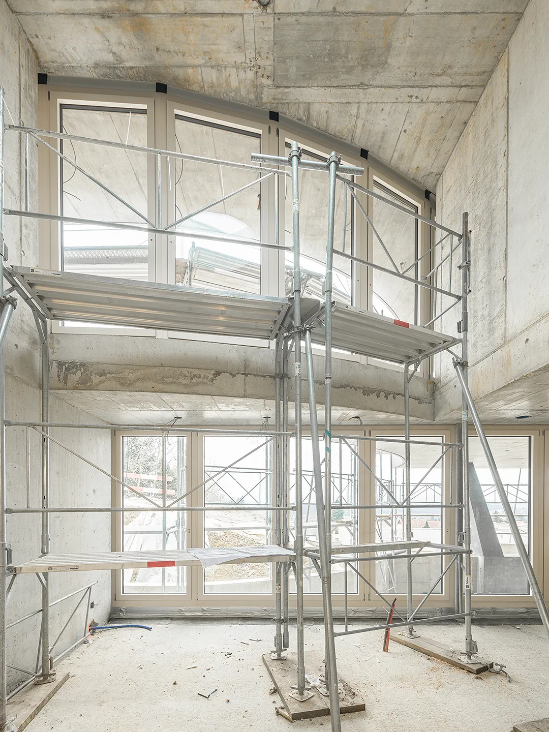 Architecture Photography of an interior of the construction-site at Winkelhaus by architects Estudio KMMK, construction by atelier rosinus, structure by schnetzer puskas. Modular windows on display.
