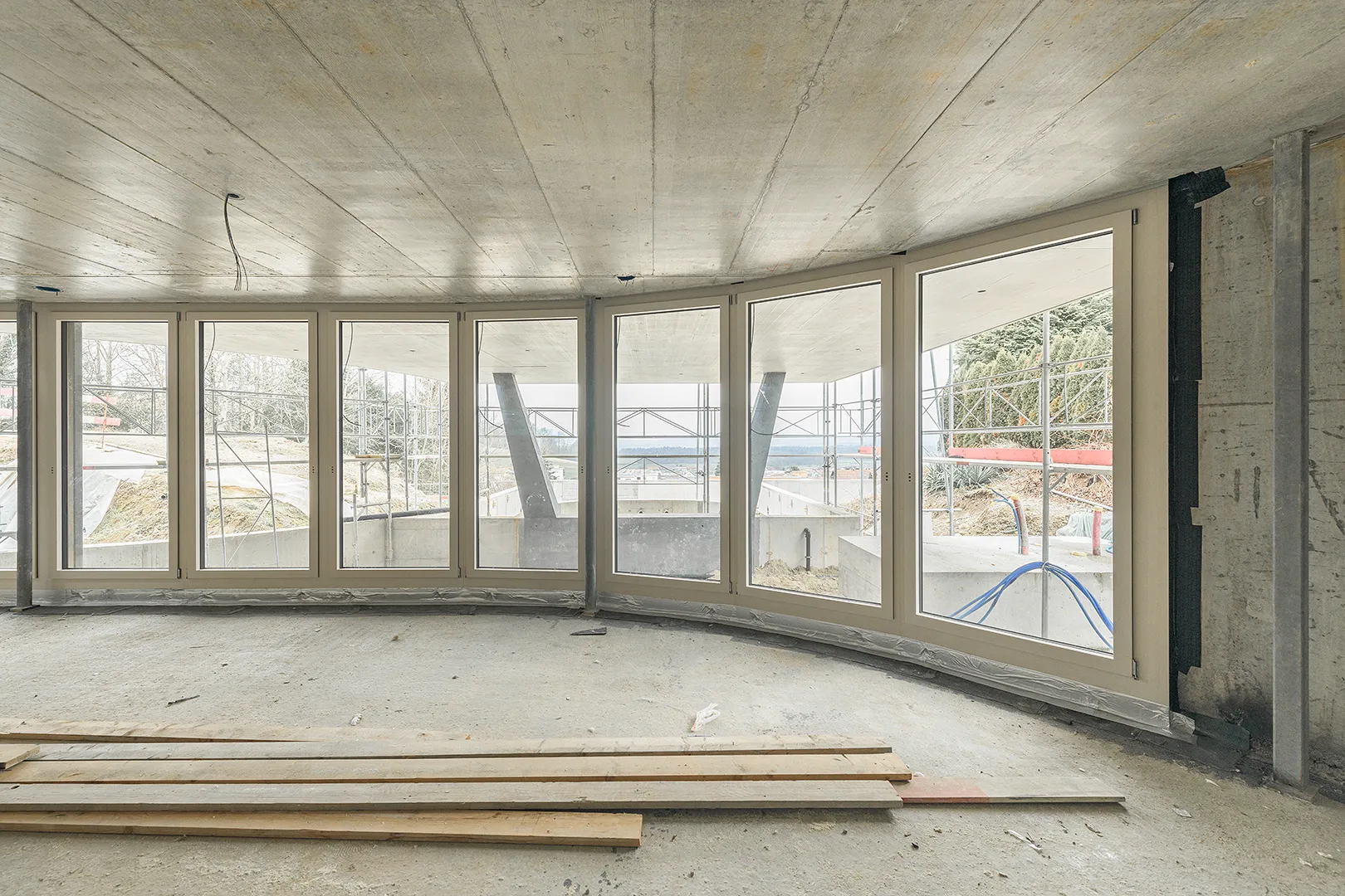 Architecture Photography of an interior of the construction-site at Winkelhaus by architects Estudio KMMK, construction by atelier rosinus, structure by schnetzer puskas. Modular windows on display.