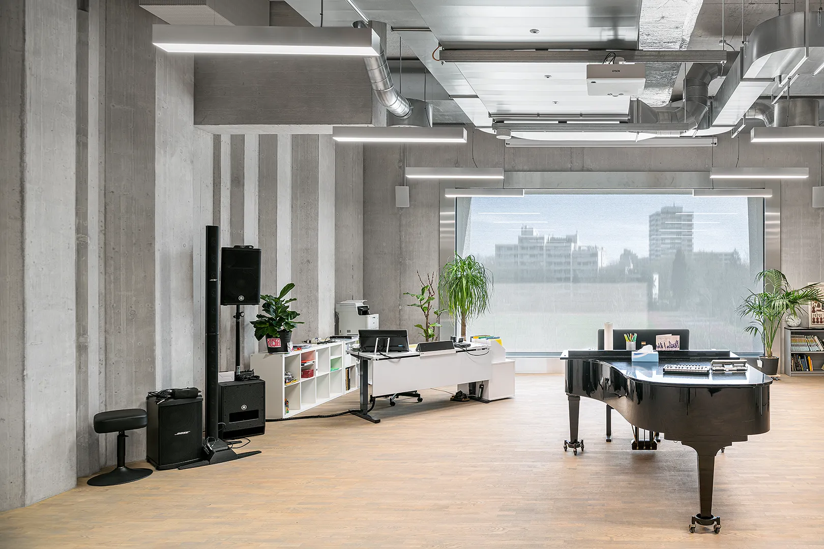 Architecture Photography of a modern brutalist-style school buildings, Kantonsschule Limmattal, featuring light gray-brown recyled-concrete facades, interior view of the music classroom with prefabricated concrete structure by ingegneri pedrazzini guidotti, designed for PENZISBETTINI in Urdorf, Zürich.