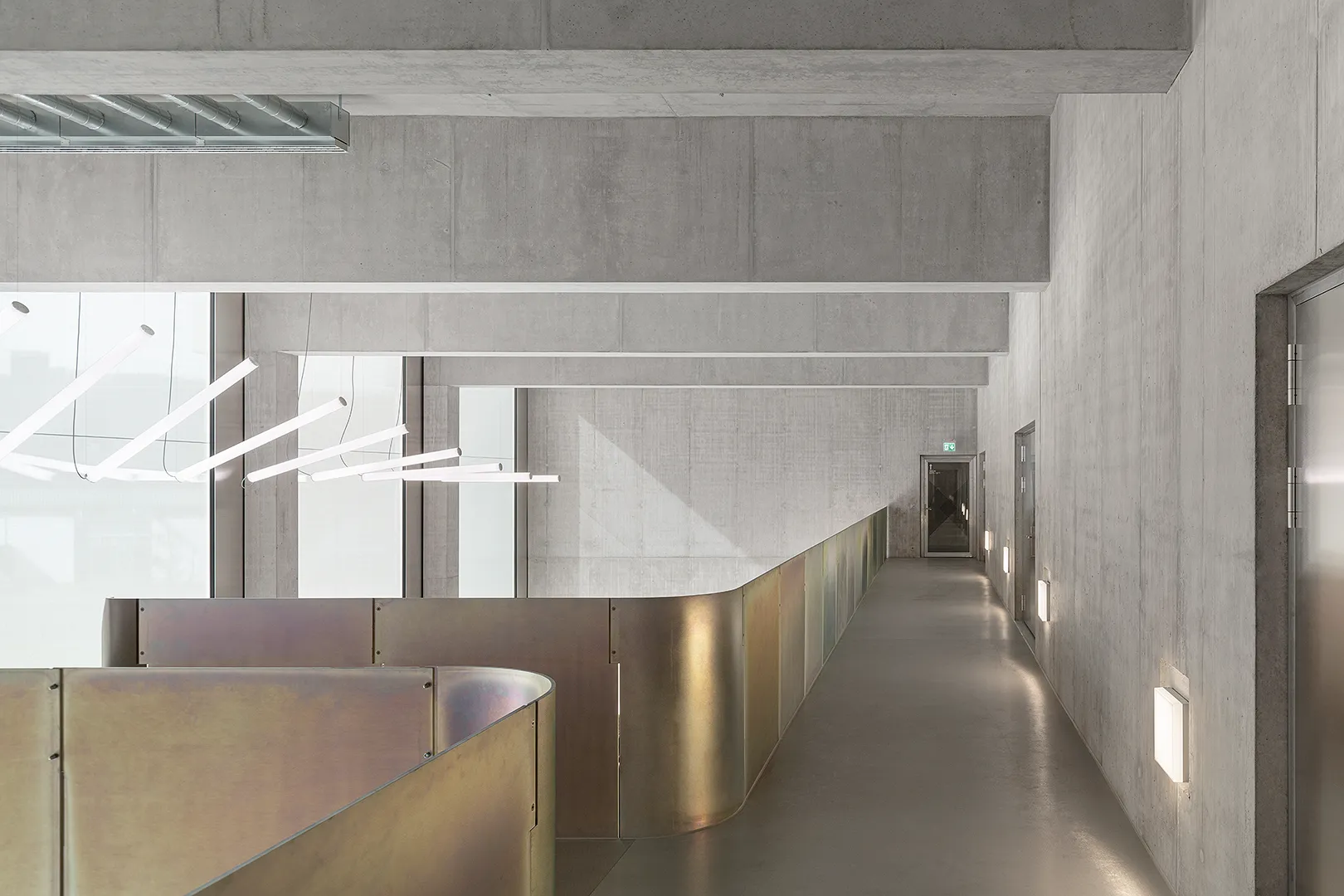 Architecture Photography of a modern brutalist-style school buildings, Kantonsschule Limmattal, featuring light gray-brown recyled-concrete facades, interior view of the entrance with prefabricated concrete structure by ingegneri pedrazzini guidotti, designed for PENZISBETTINI in Urdorf, Zürich.